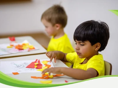 Duas crianças fazendo atividade com papéis coloridos