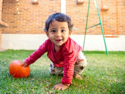 Bebê brincando feliz no quintal de casa