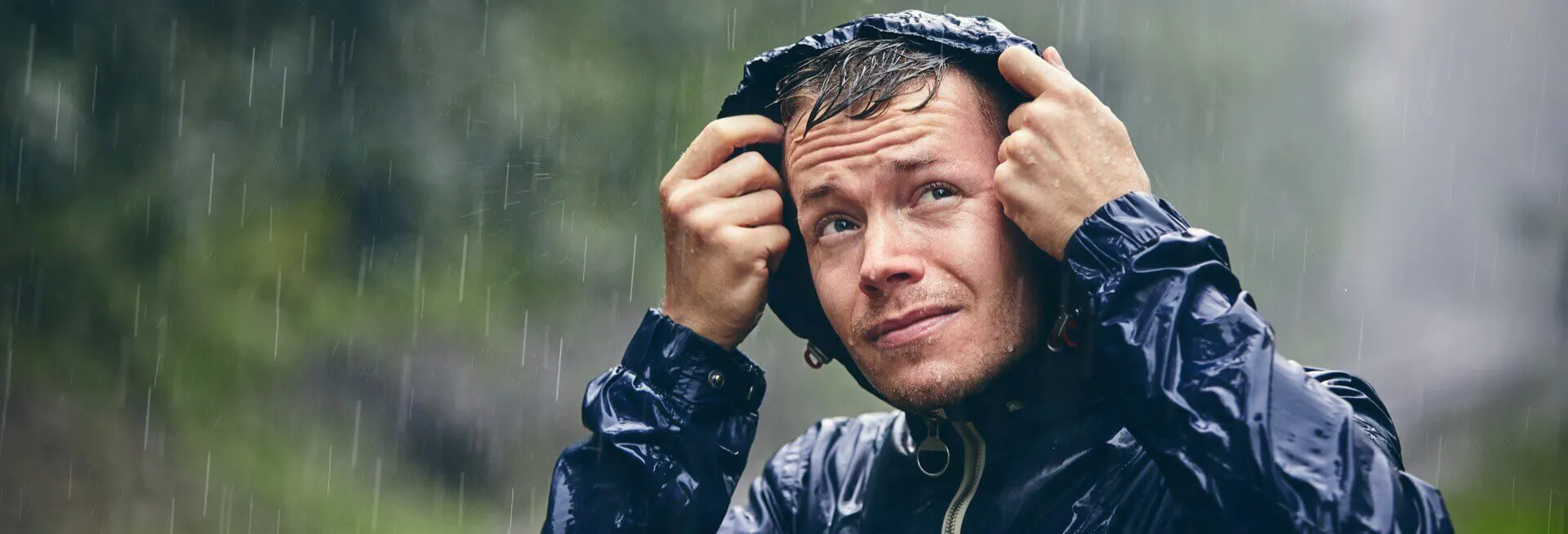 Homem com uma capa de chuva na chuva