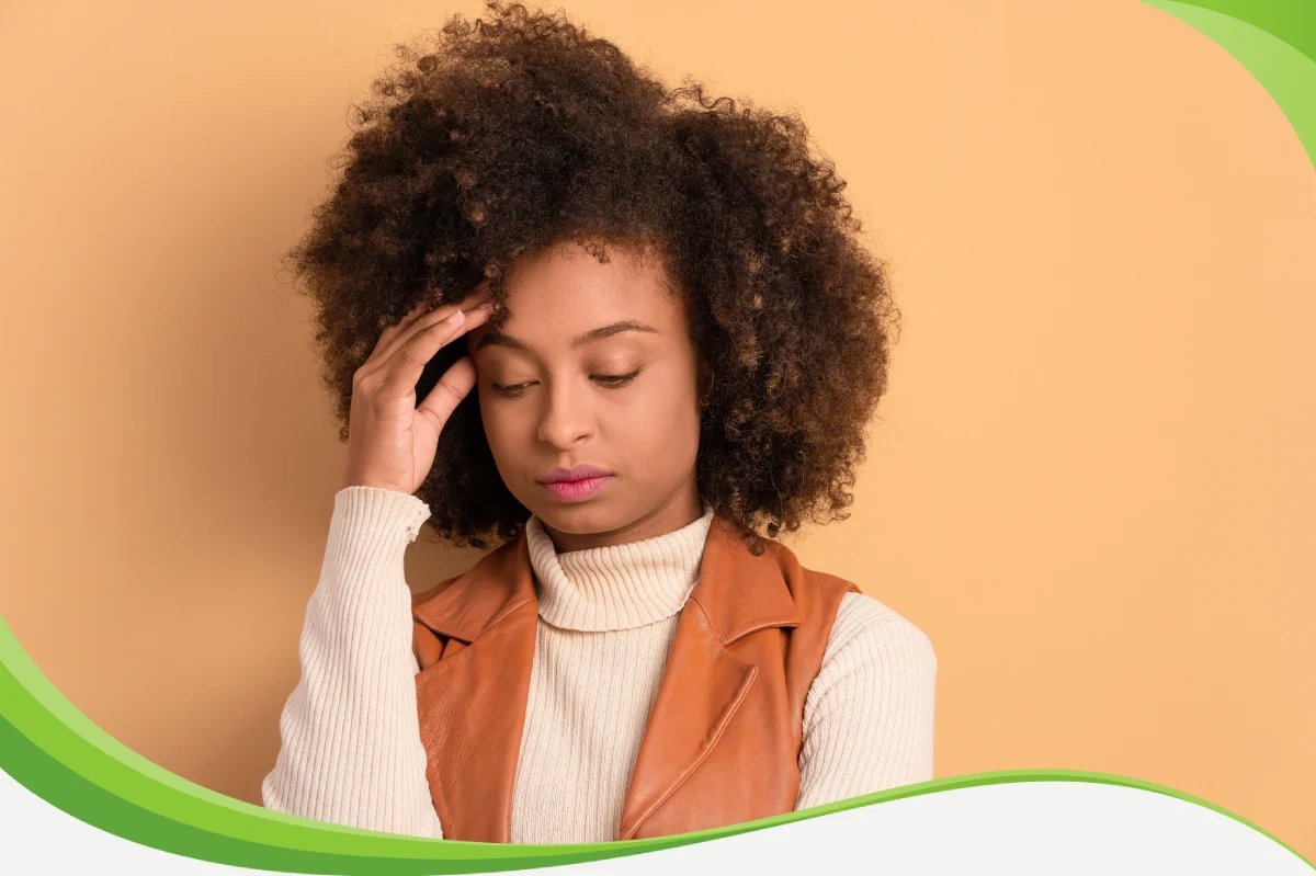 Mulher olhando para baixo, tocando a testa com os dedos da mão direita. O pano de fundo combina com sua roupa.